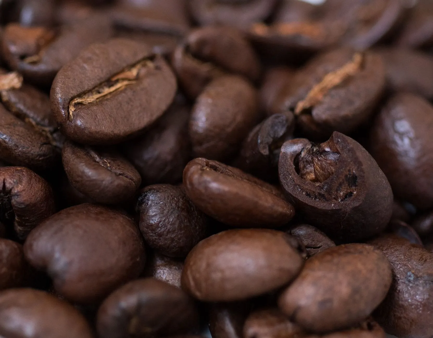 Close view of dark, glossy medium-dark roasted beans