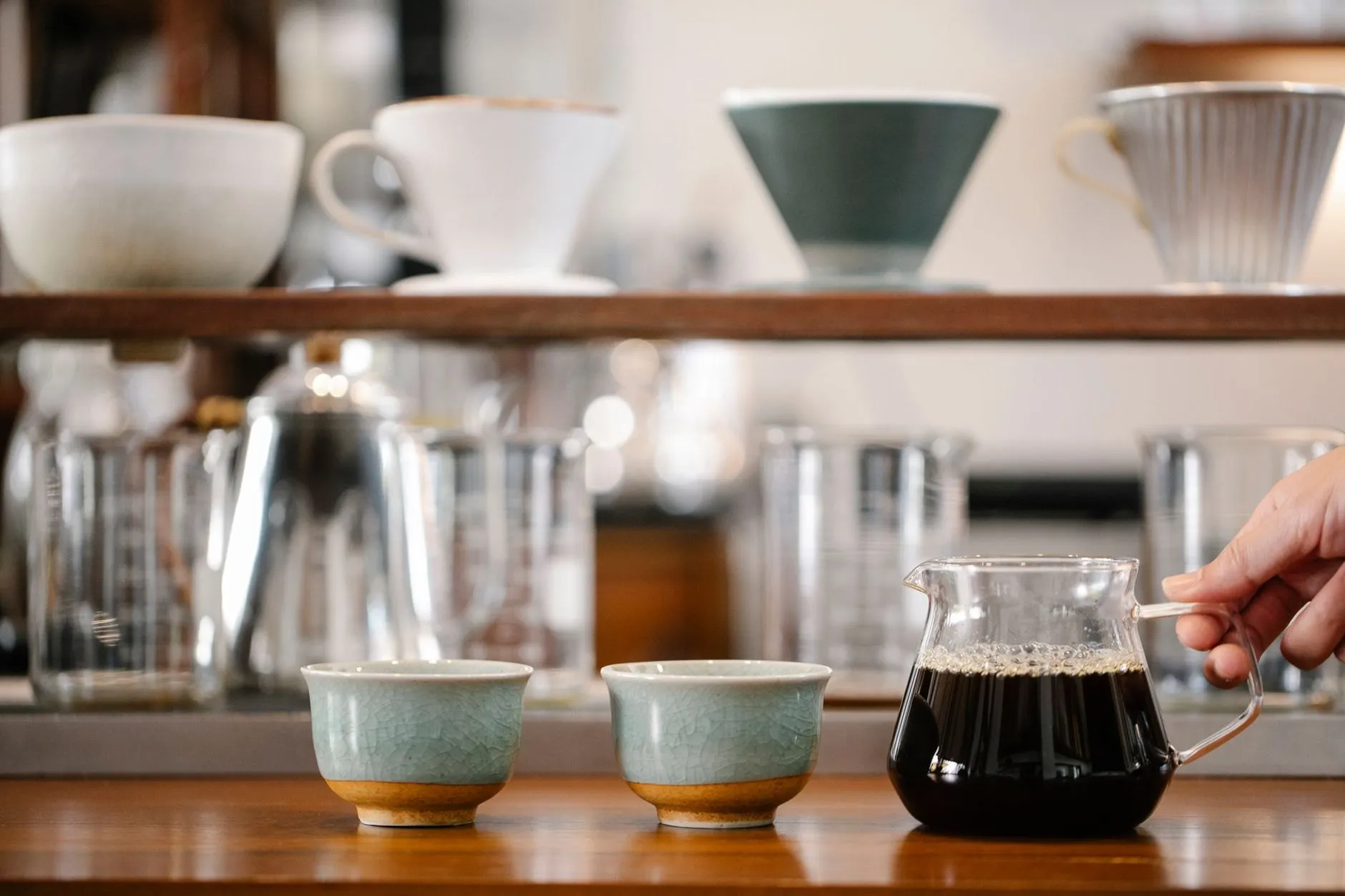 Cups and a glass server of filter coffee on the café counter
