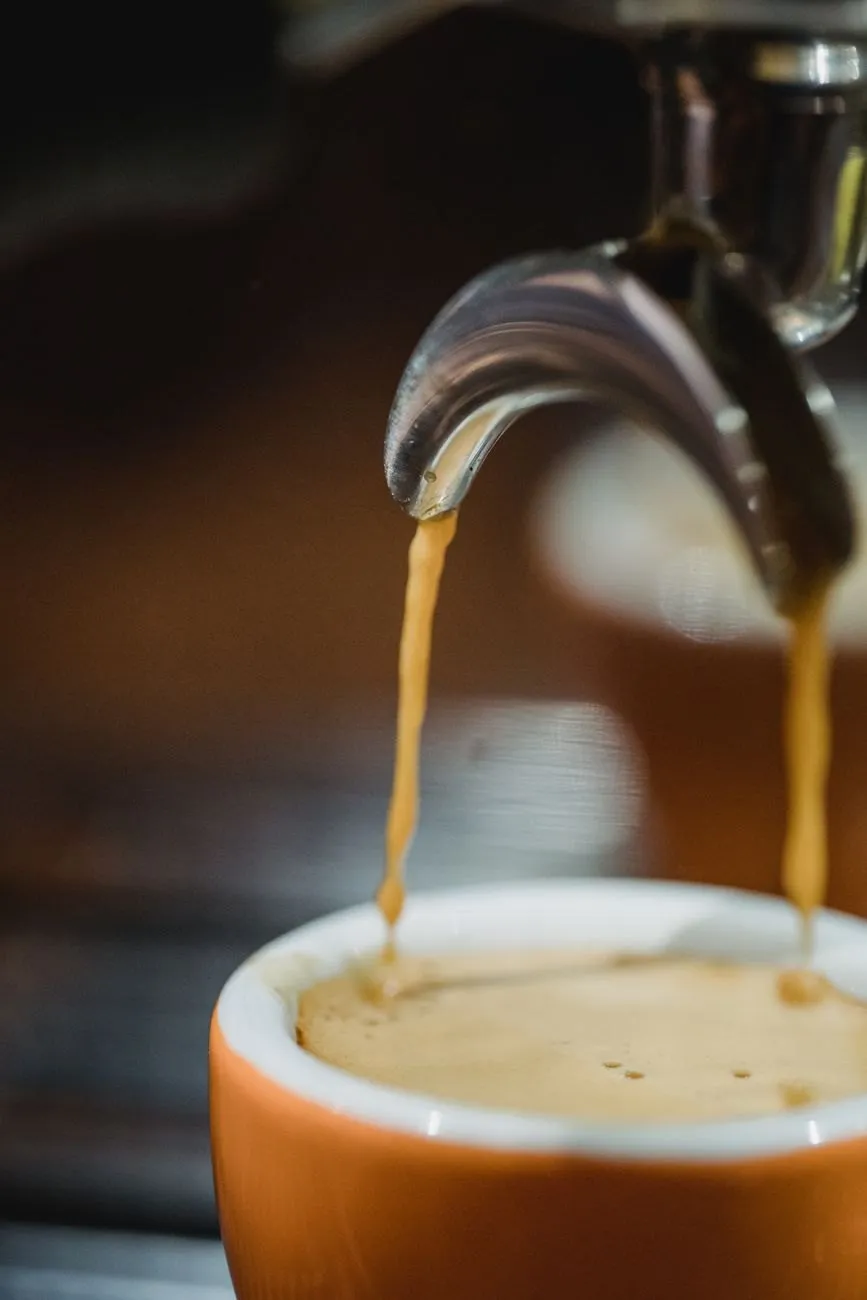 Espresso running from a spouted portafilter into an orange cup