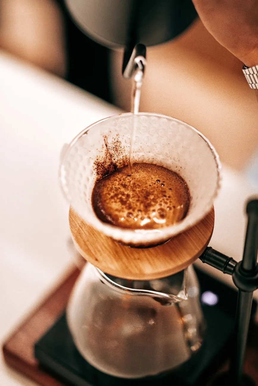 Filter coffee blooming in a paper cone as water is poured